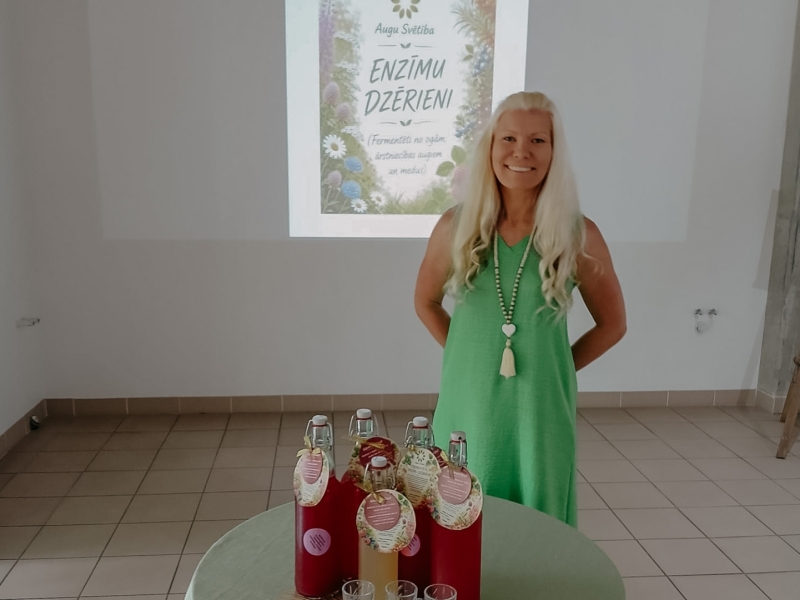 Sieviete prezentē savu produktu - enzīmu dzērienu