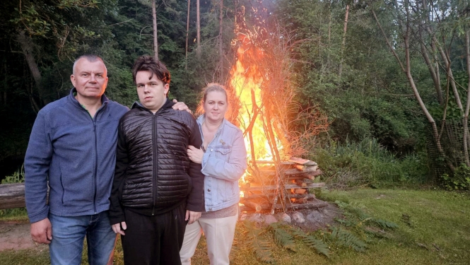 Trīs cilvēki pie ugunskura