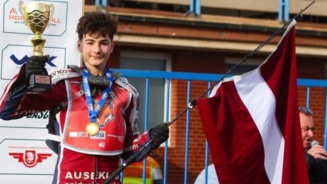 Spīdvejists Hugo Poļaks ar Latvijas karogu un kausu