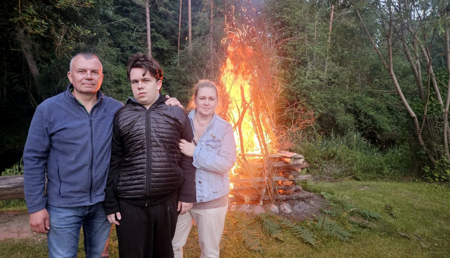 Trīs cilvēki pie ugunskura