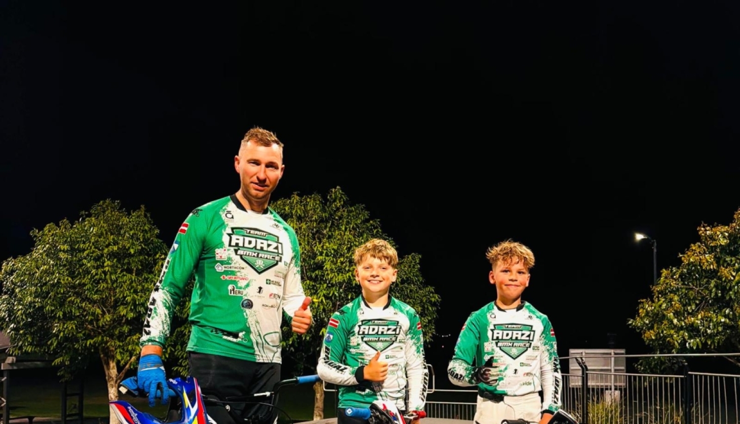 Trīs BMX sportistie ar riteņiem.