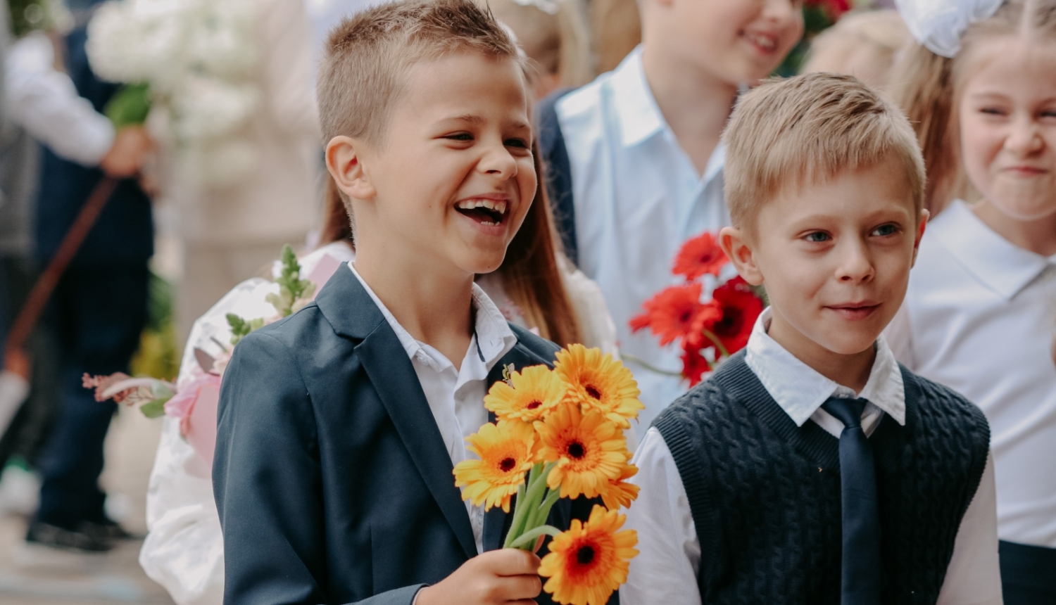 Zinību diena - smaidīgi skolēni ar ziediem rokās
