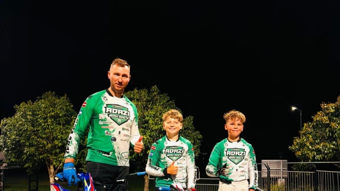 Trīs BMX sportistie ar riteņiem.