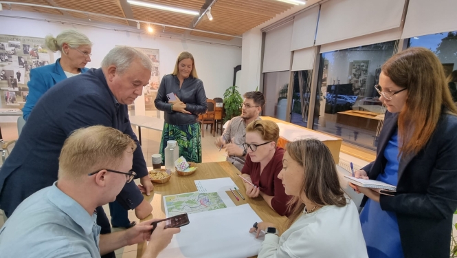 vairaki cilvēki ap galdu, notiek diskusija