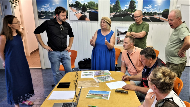 vairāki cilvēki ap galdu, runā, plāno