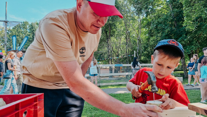 Nometne - tētis palīdz dēlam, naglas dzīšana kokā