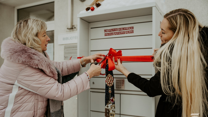 atklāj bibliomātu, 2 sievietes griež atklāšanas lentu