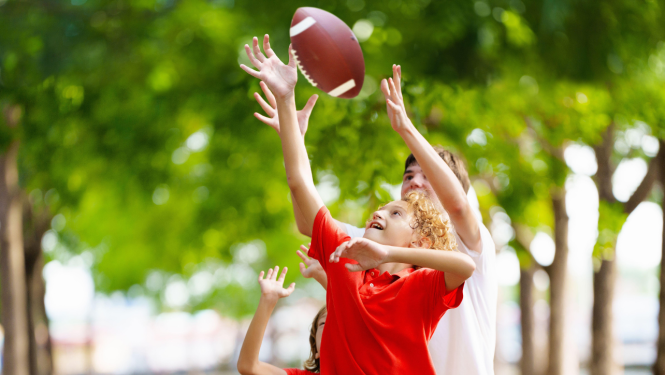 zēni spēlē bumbu - regbiju parkā