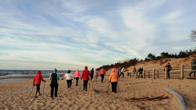 nūjotāji jūras malā