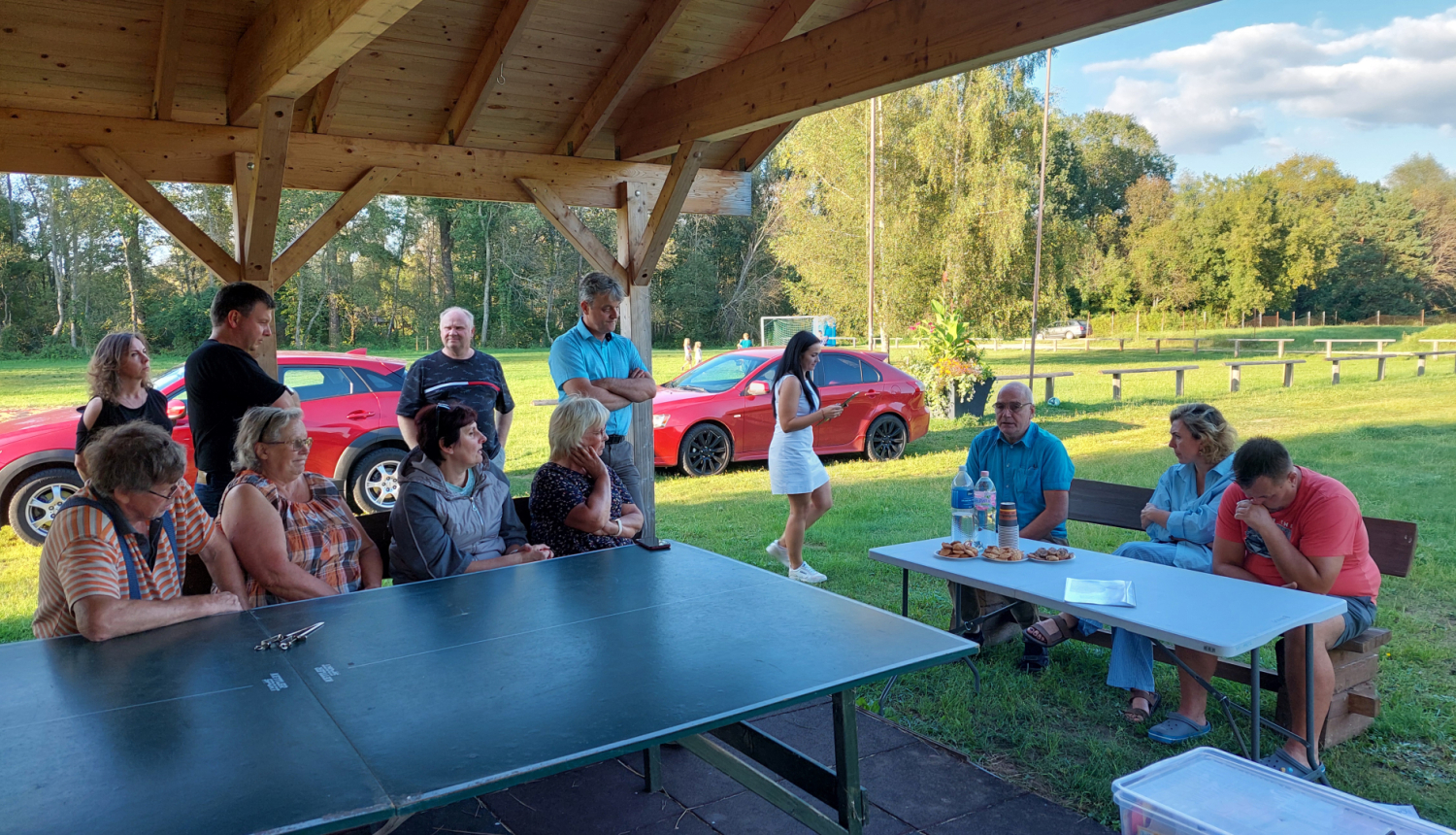 cilvēki sapulcējušies ap galdu