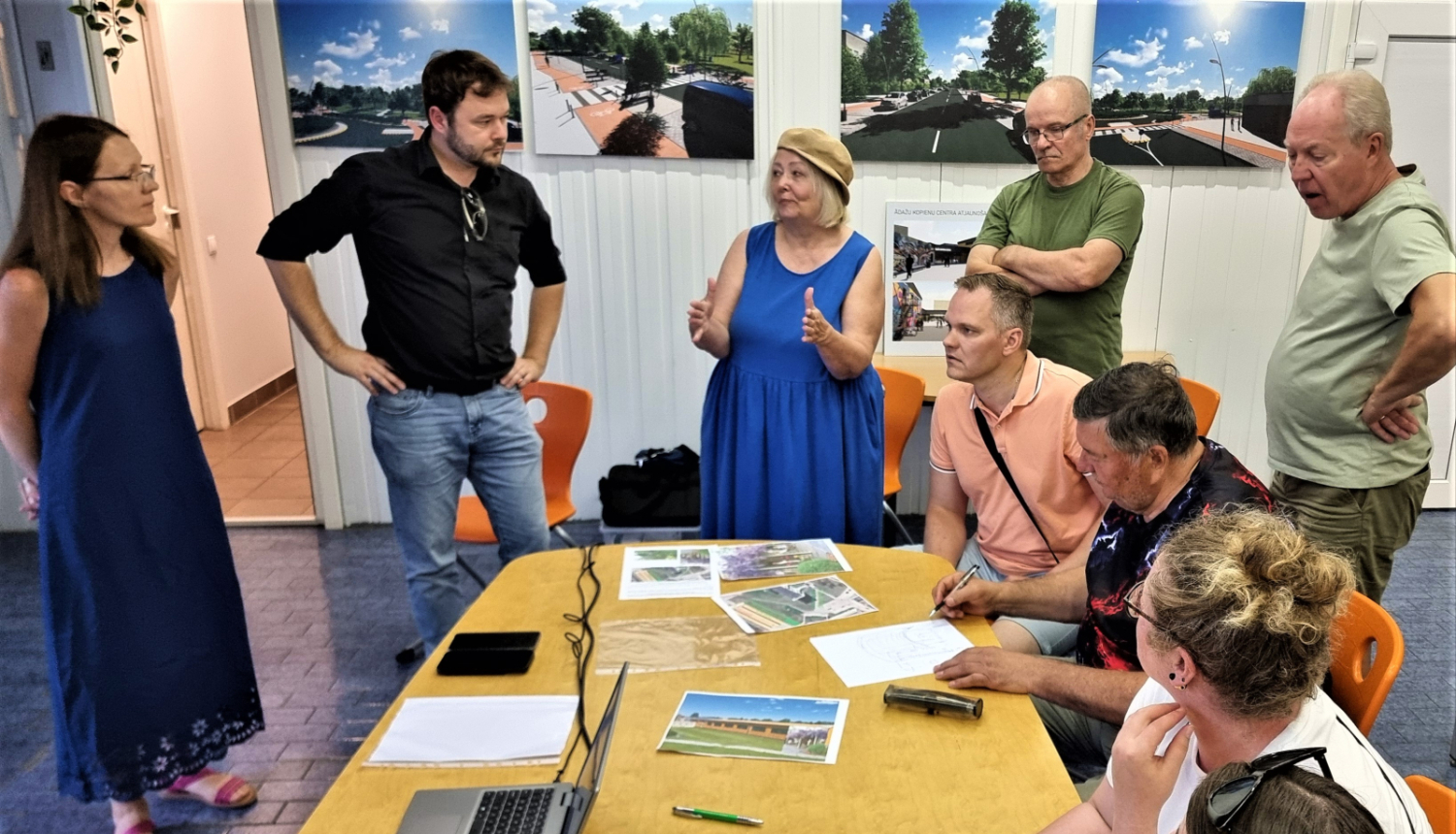 vairāki cilvēki ap galdu, runā, plāno