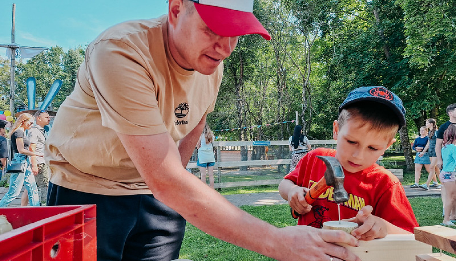 Nometne - tētis palīdz dēlam, naglas dzīšana kokā