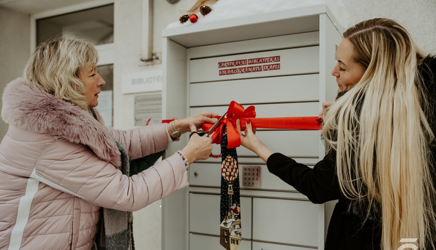 atklāj bibliomātu, 2 sievietes griež atklāšanas lentu