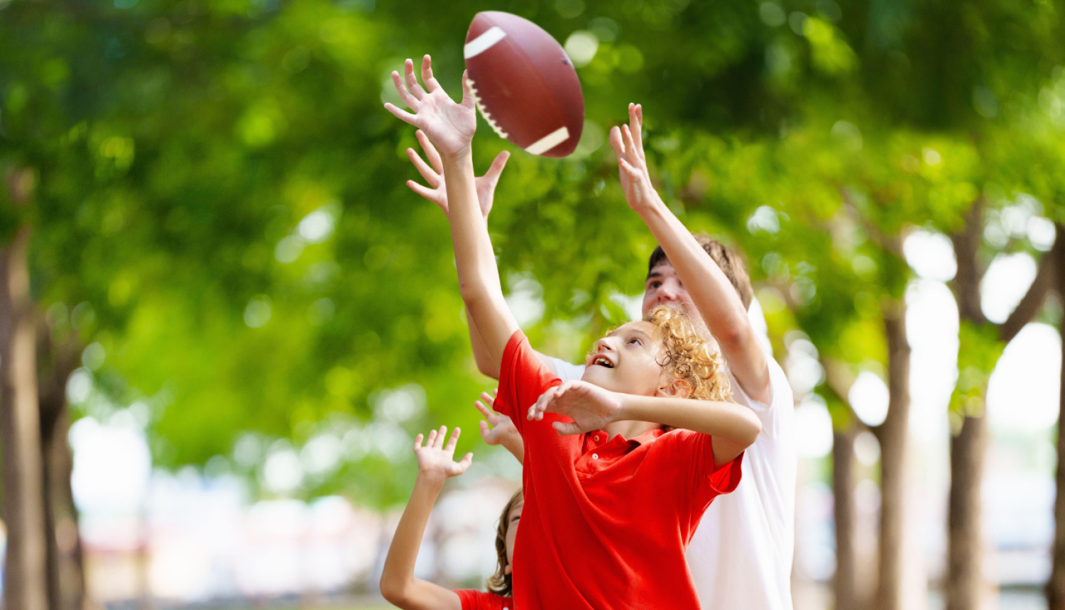 zēni spēlē bumbu - regbiju parkā