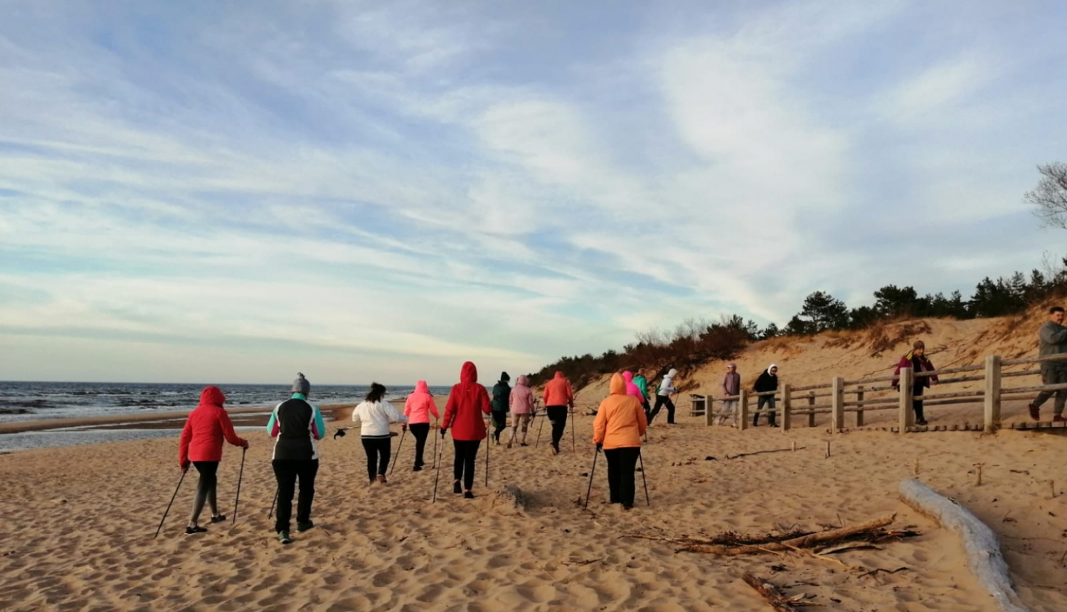 nūjotāji jūras malā